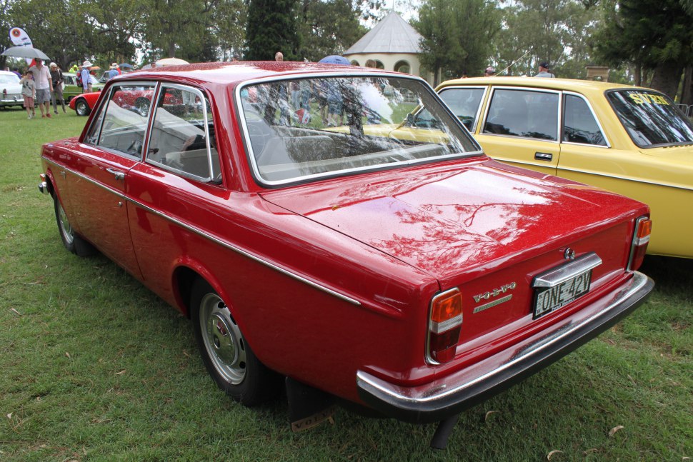 Rear view of red classic Volvo 140 series sedan with chrome details