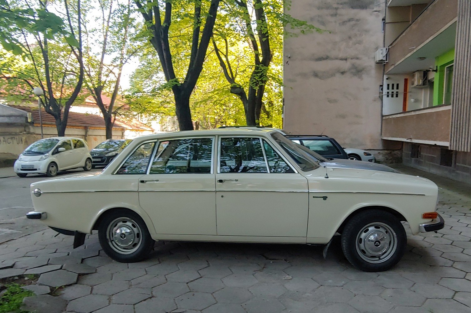 Classic vintage sedan with chrome hubcaps and boxy design.