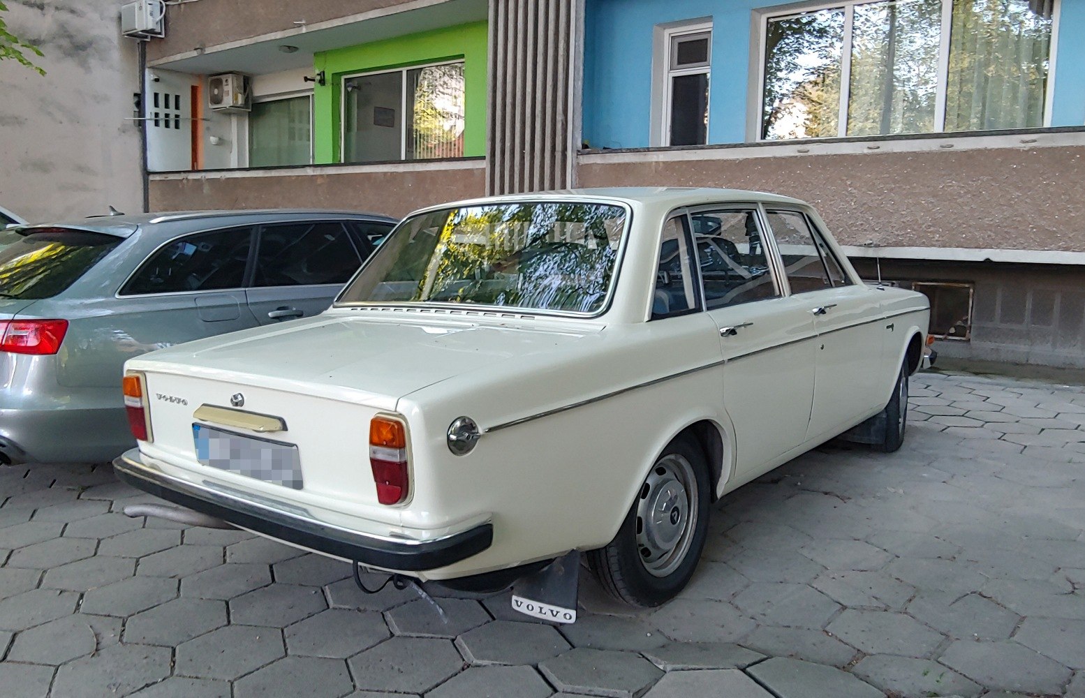 Rear side view of a classic vintage sedan with chrome trim and rectangular taillights