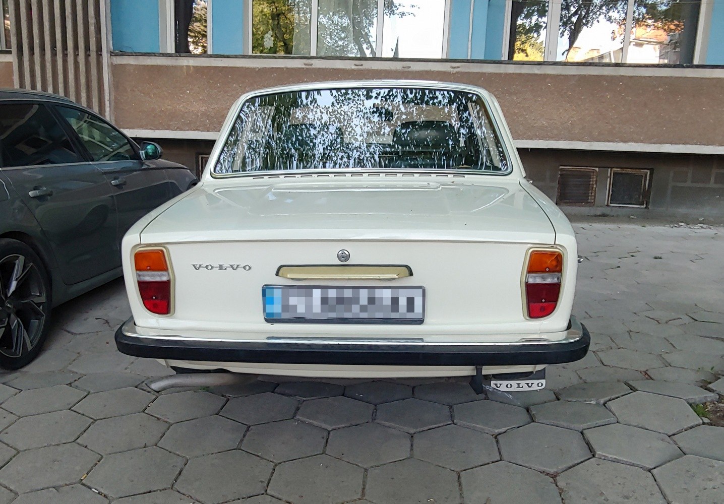Rear view of a vintage sedan with distinctive rectangular tail lights and black bumper.