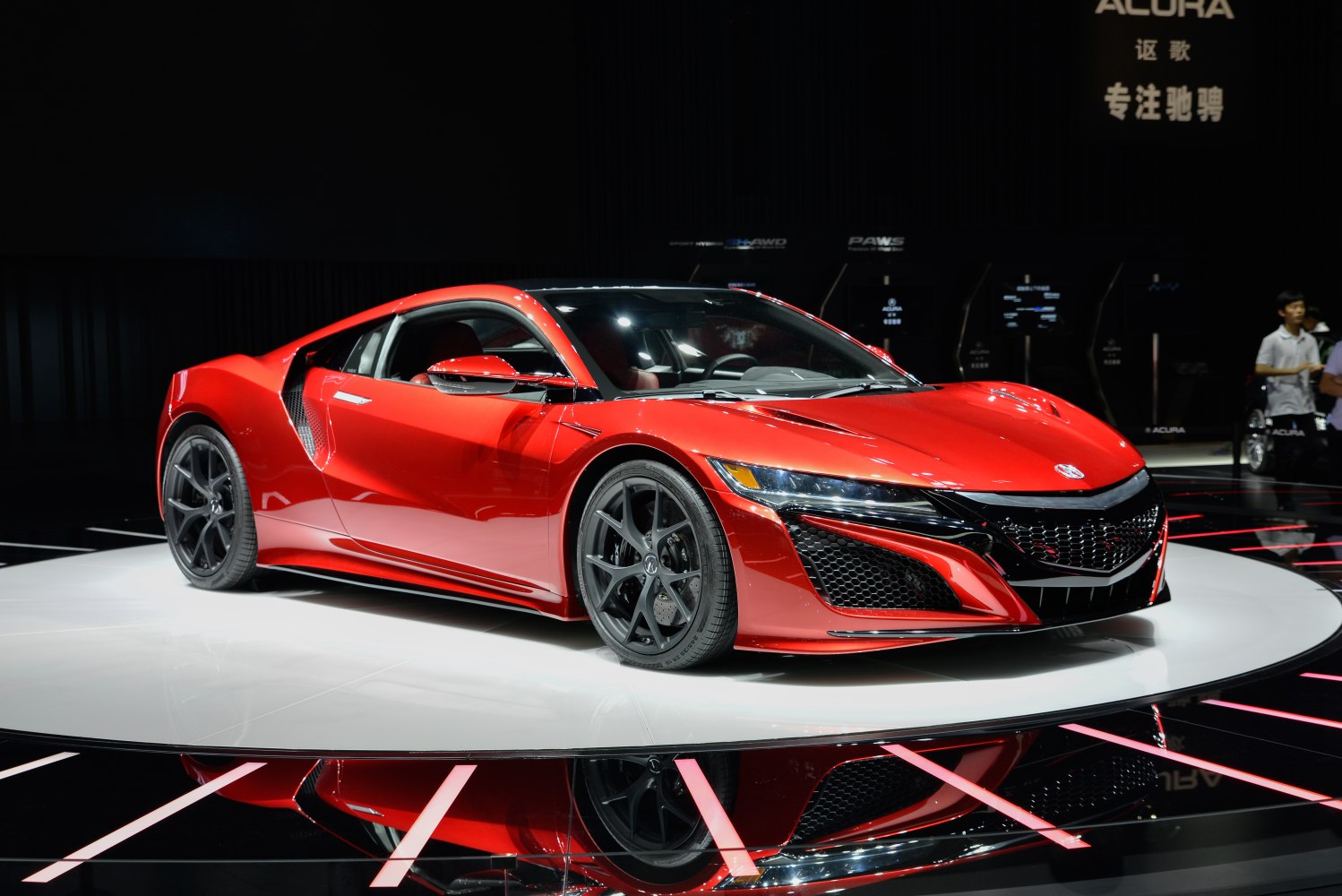 Red sport coupe with LED headlights and aggressive grille on display