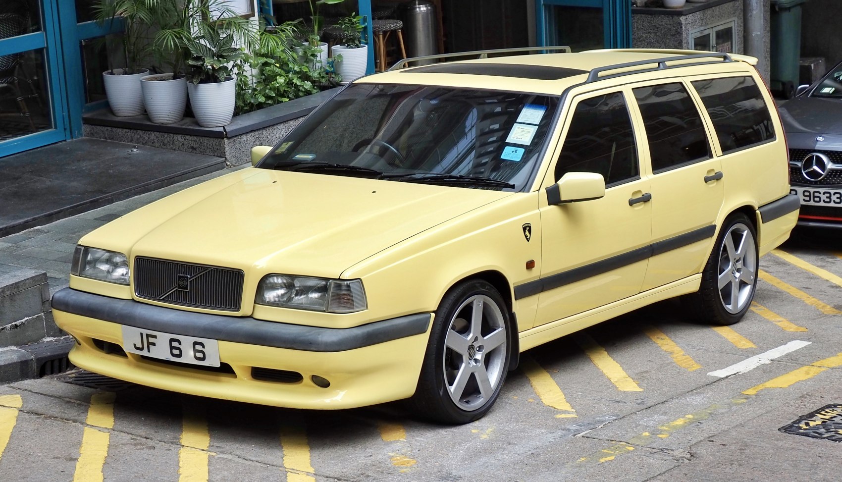 Yellow station wagon with alloy wheels and sunroof, front-side view