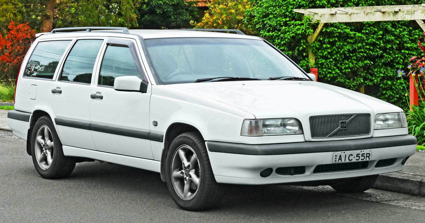 White vintage station wagon with roof rails and alloy wheels