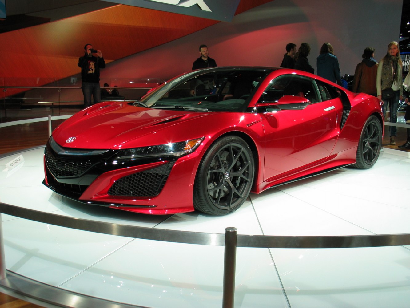 Red sports car with aggressive front grille and aerodynamic side intakes.