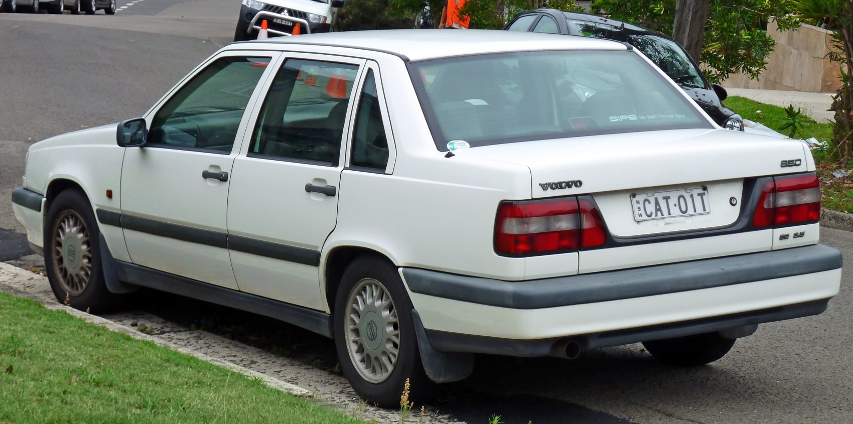 Rear and side profile of classic mid-90s sedan with distinct taillights
