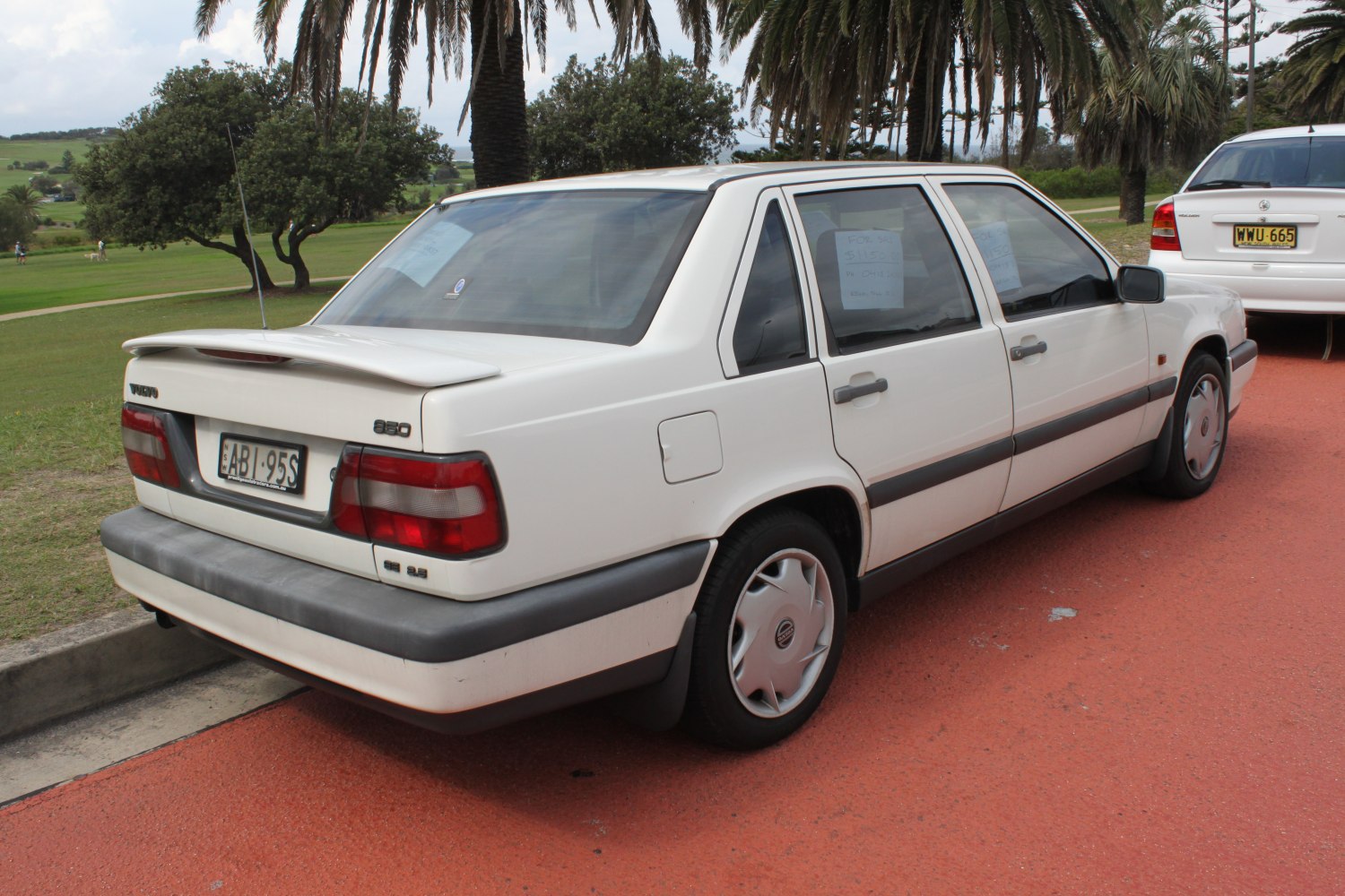 Rear side view of a mid-90s sedan with rear spoiler and classic rear lights