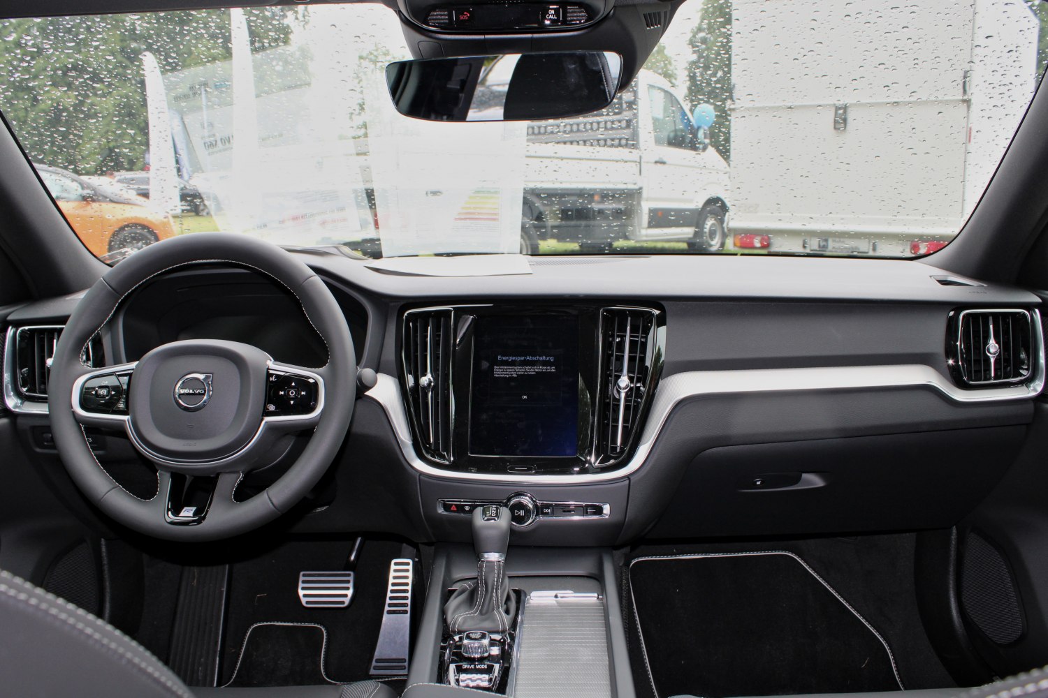Modern car dashboard with touchscreen and multifunction steering wheel.