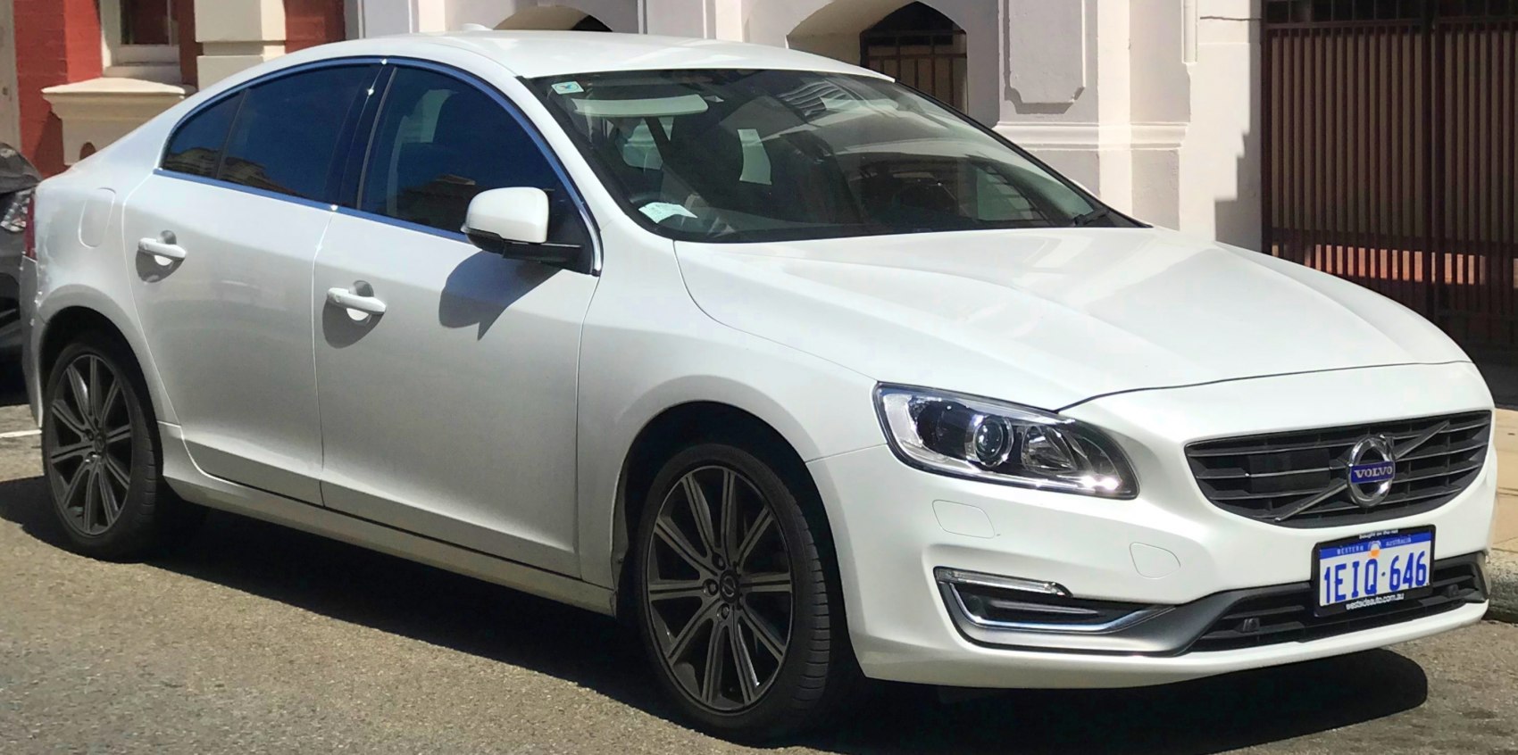 Front side view of white sedan with modern headlights and alloy wheels
