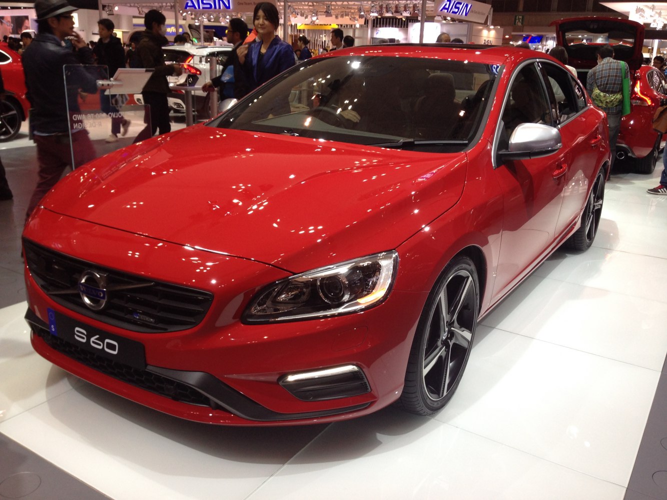 Red sporty sedan front angle with distinctive headlights and alloy wheels