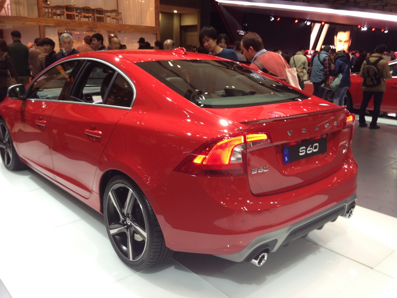 Rear and side profile of a red sedan with distinctive taillights and sporty rims