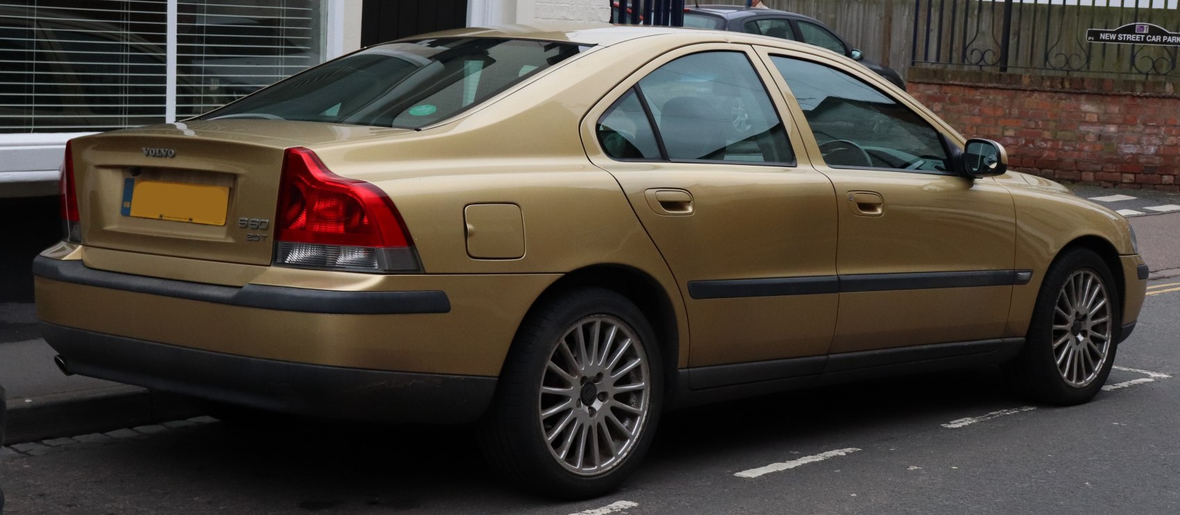 Rear and side view of a four-door sedan with distinctive tail lights and alloy wheels