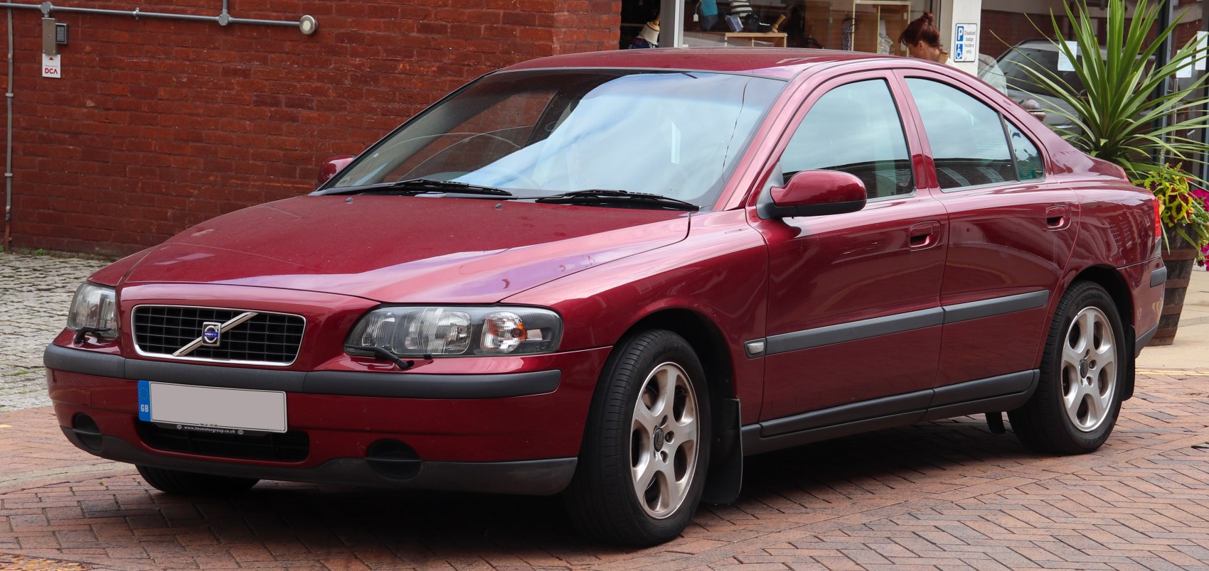 Red mid-size sedan with distinct Volvo grille and headlights.