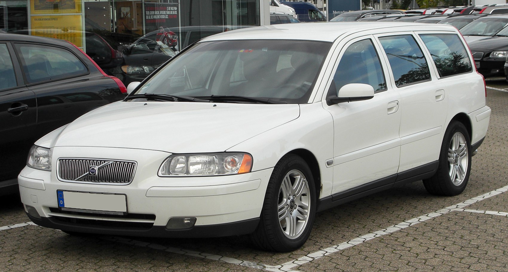 White station wagon front three-quarter view with alloy wheels and grille
