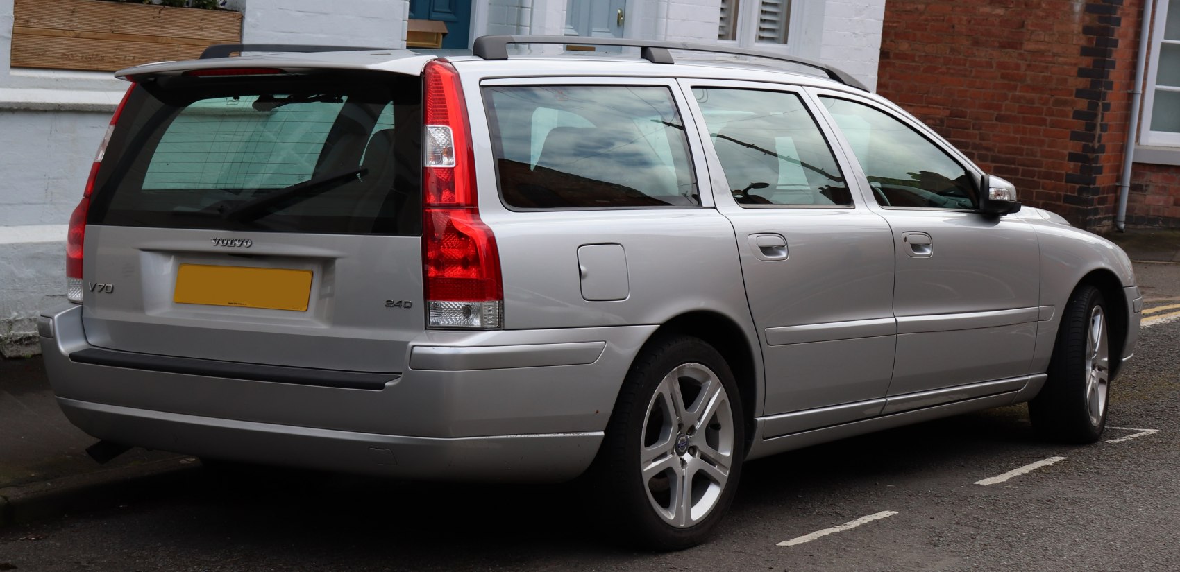 Rear side view of silver estate car with vertical taillights and alloy wheels