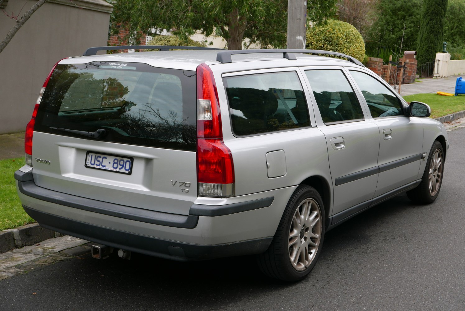 Rear view of silver station wagon with vertical tail lights and roof rails