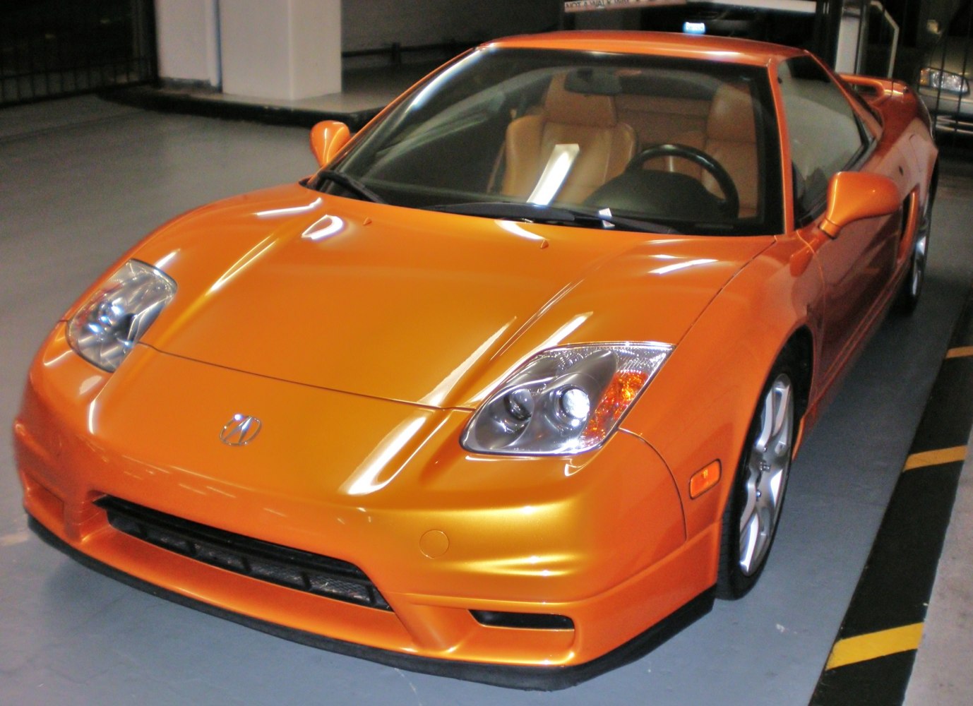 Orange sports coupe front angle with dual aerodynamic headlights