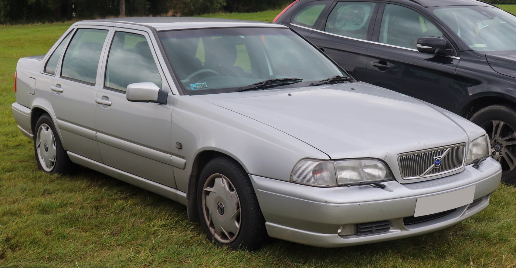 Silver four-door sedan with unique front grille and hood wipers