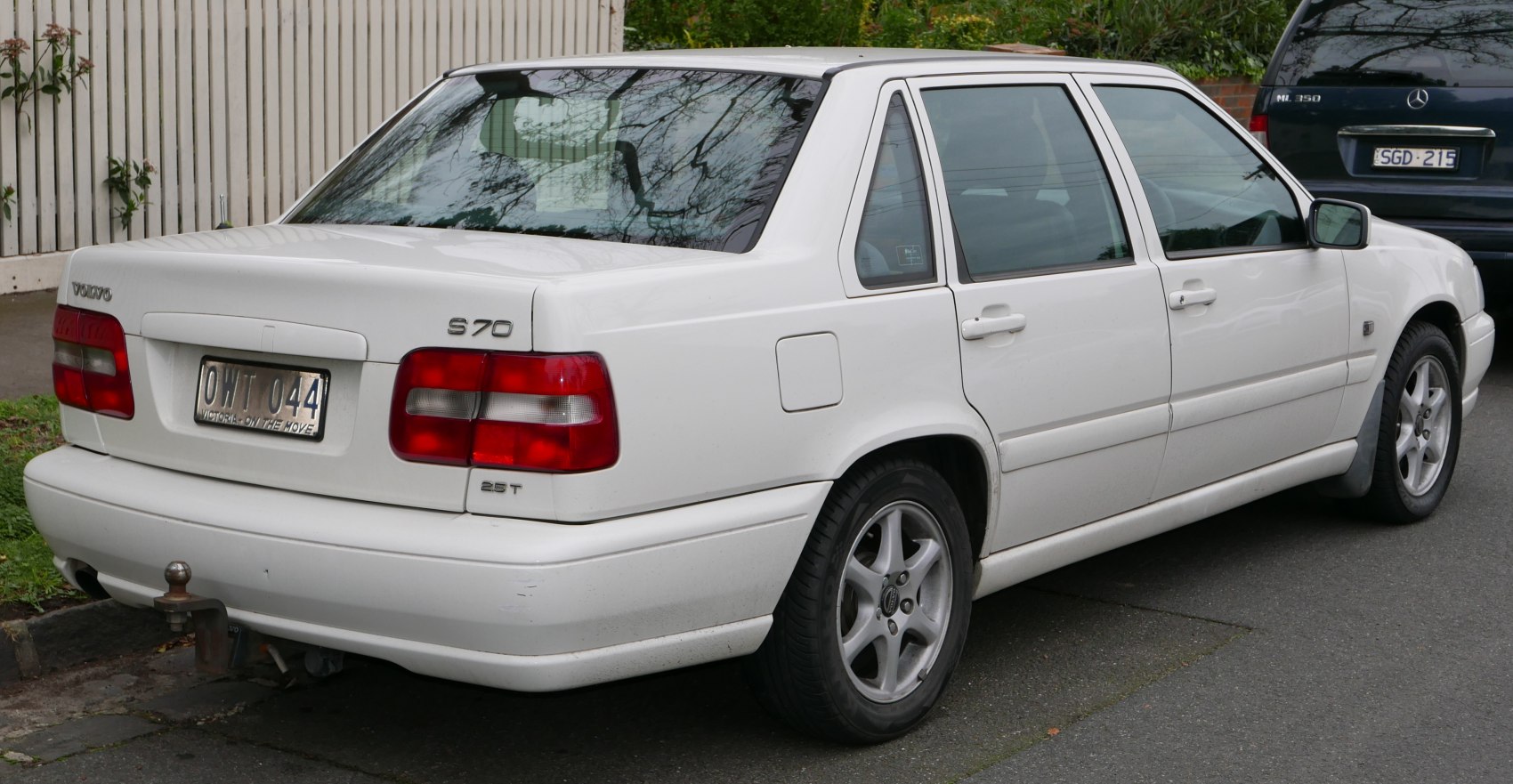 Rear side view of sedan with tow hitch and alloy wheels