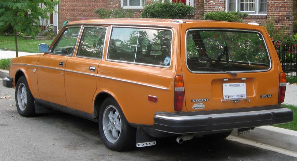Rear and side profile of a vintage station wagon with orange paint