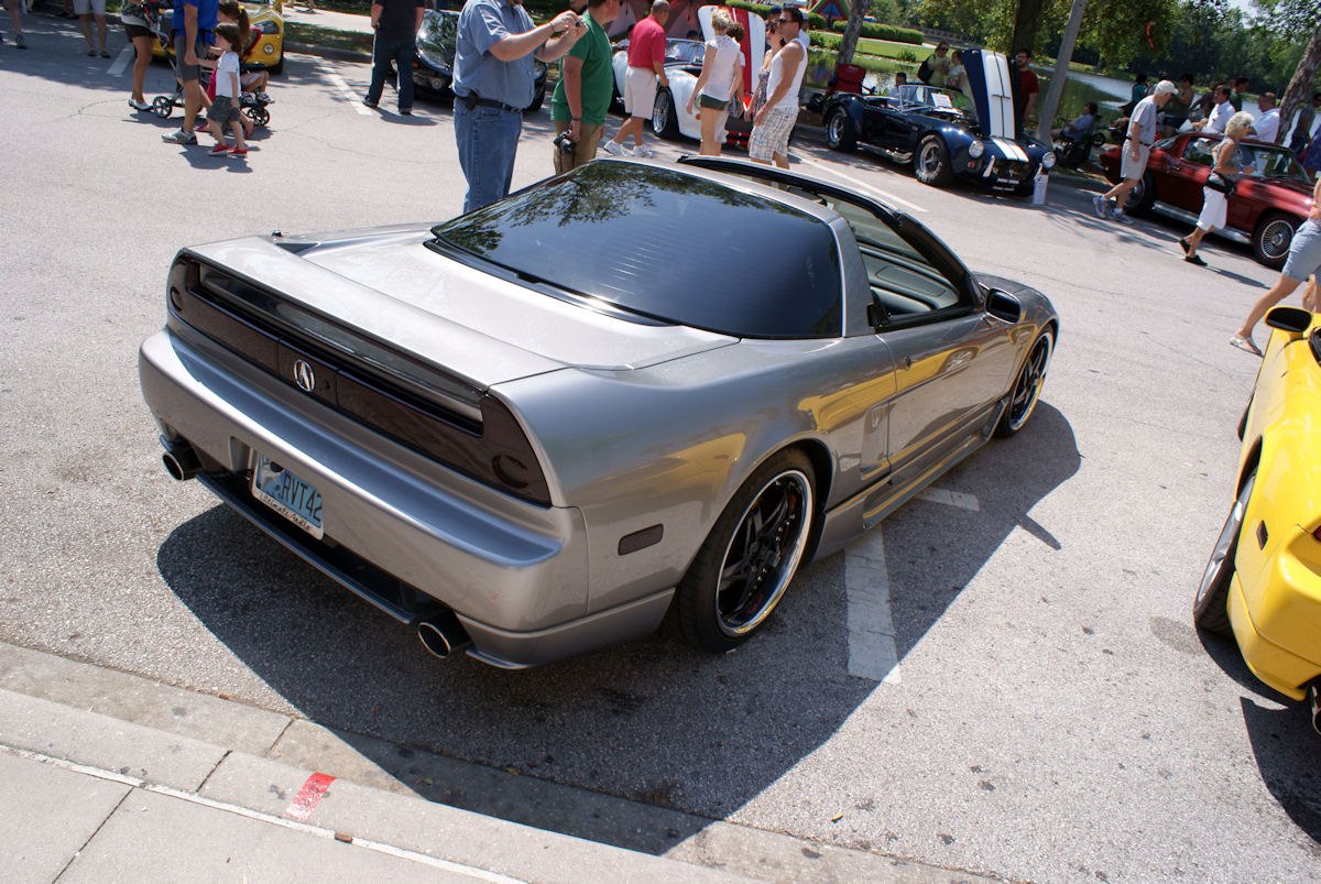 Rear view of a silver sports car with targa roof and dual exhausts
