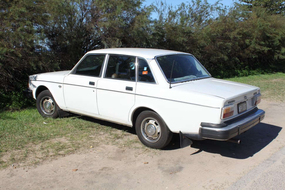 White vintage sedan with steel wheels and rear antenna