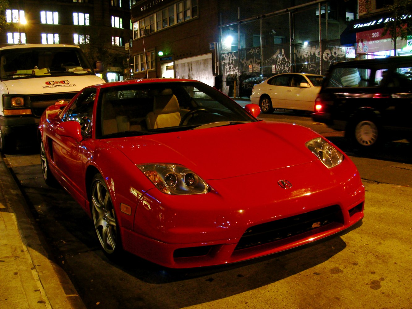 Red sports coupe with distinct angular headlights and sleek aerodynamic front