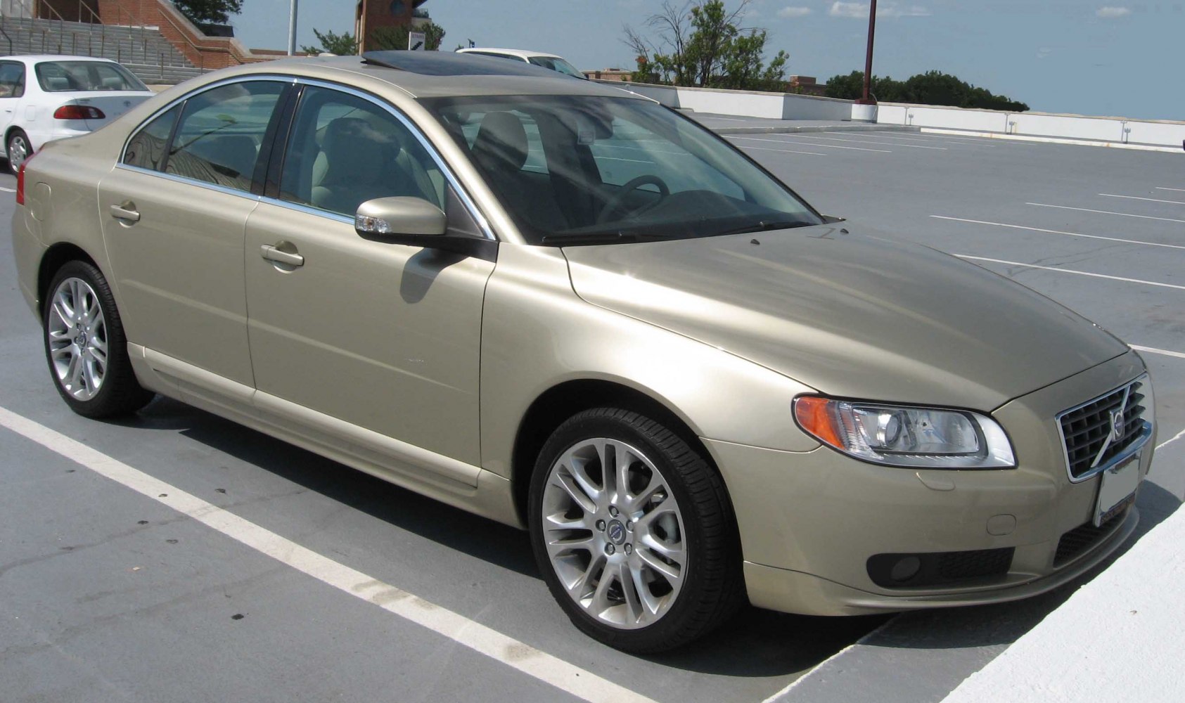 Front side view of a beige luxury sedan with alloy wheels.