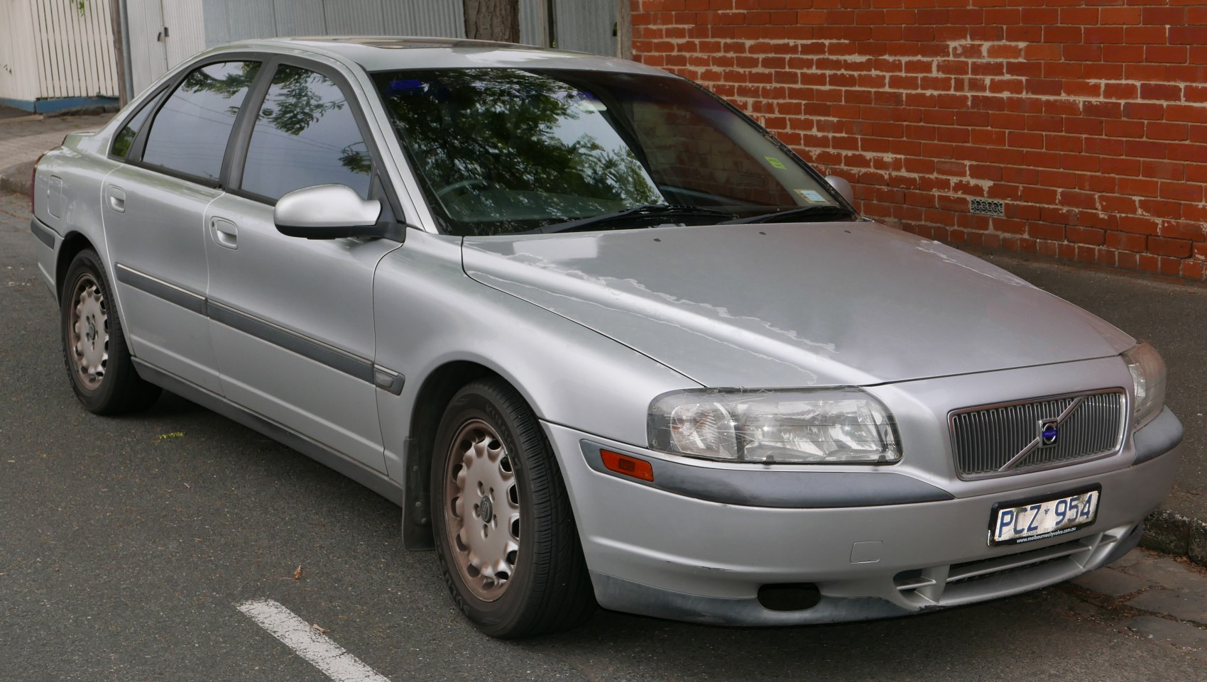 Front side view of sedan with classic headlights and distinct grille