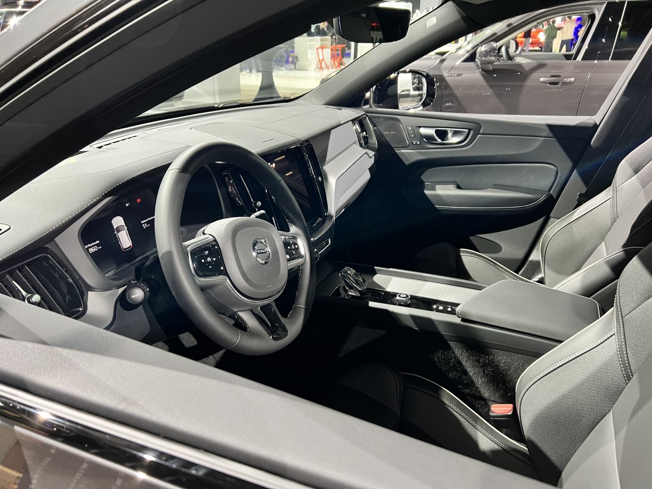 Modern dashboard and steering wheel with digital instrument cluster and ergonomic seats.