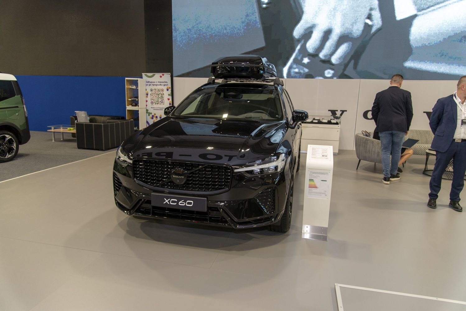 Black SUV front view with roof luggage box and distinctive grille.