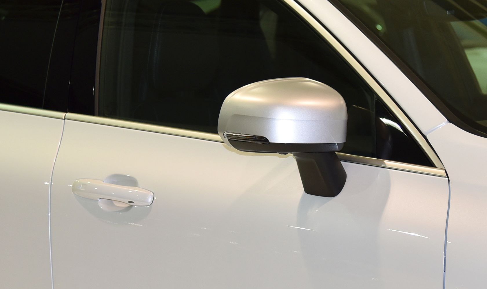 Side mirror and door handle detail on white SUV door