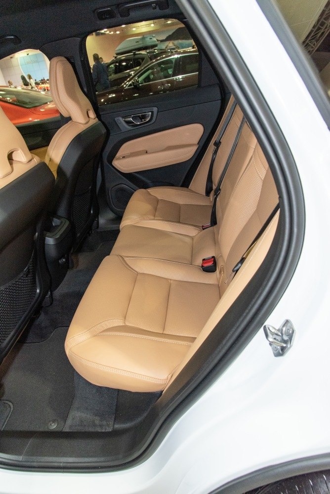Rear seat interior with tan leather upholstery and rear door panel