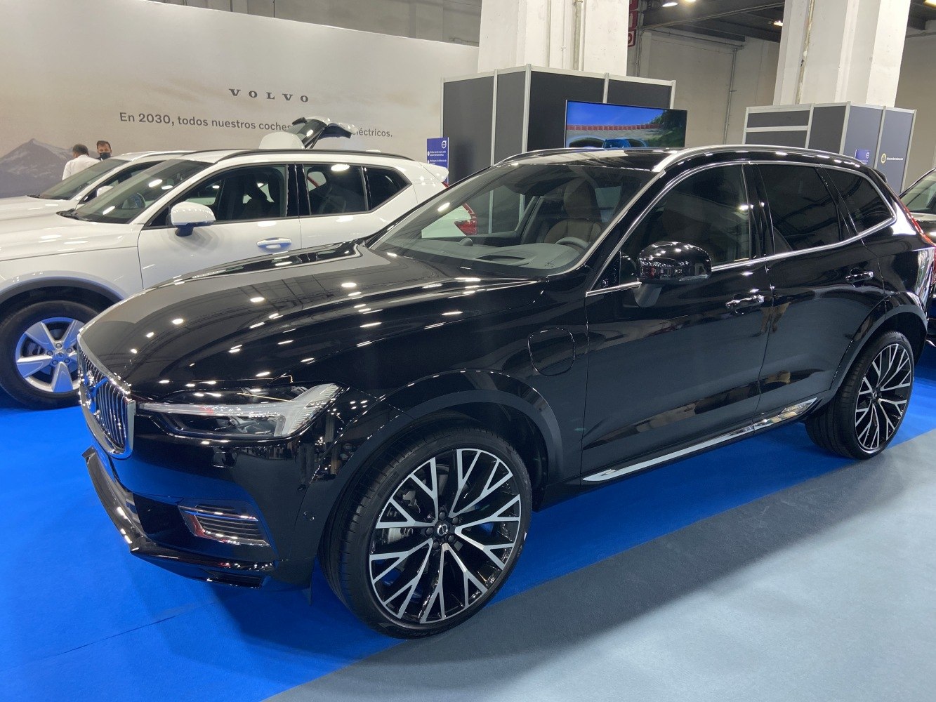 Black luxury SUV with large multi-spoke alloy wheels on blue indoor floor