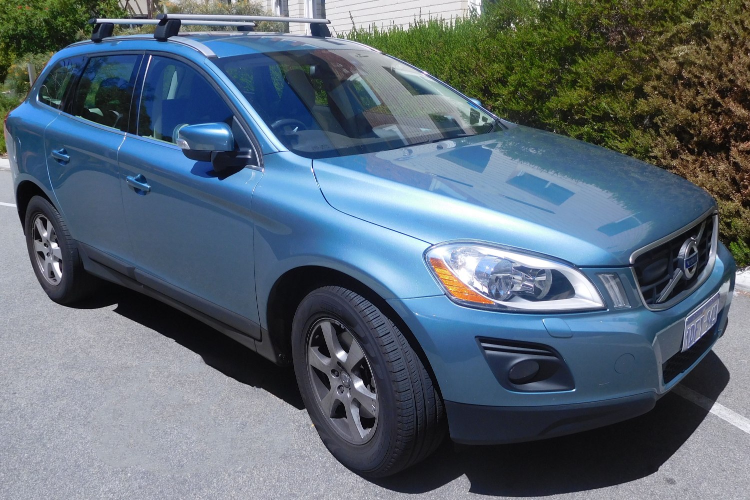 Front-side view of an SUV with headlights, alloy wheels, and roof rails