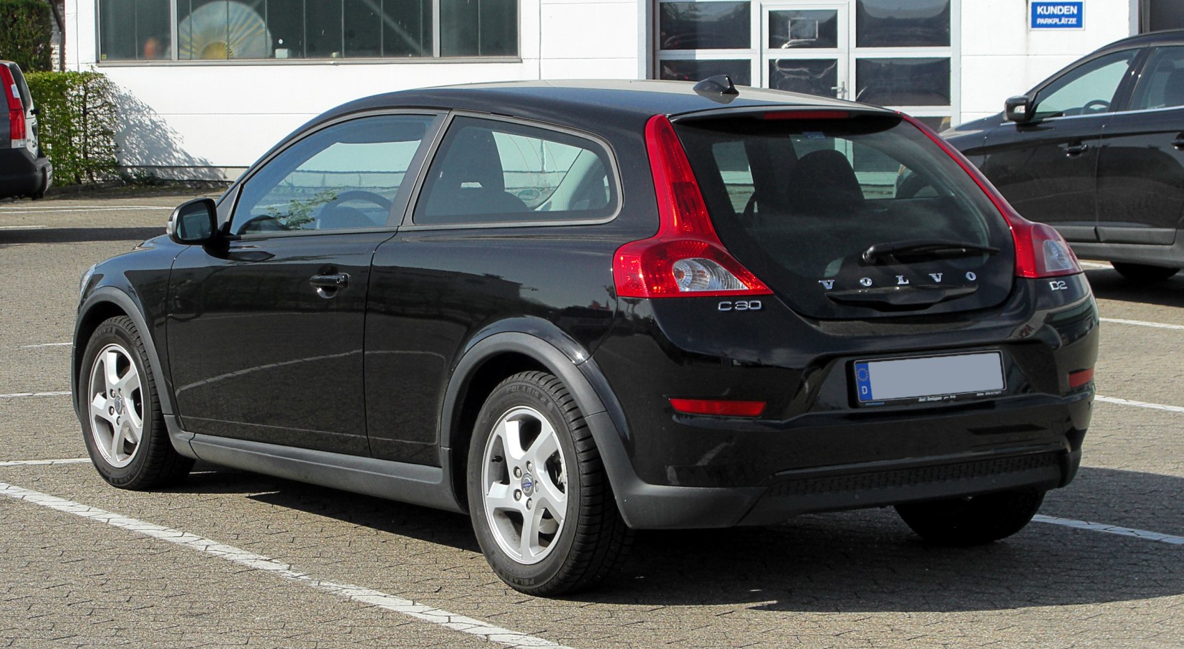 Rear view of black hatchback with vertical tail lights and three-door design
