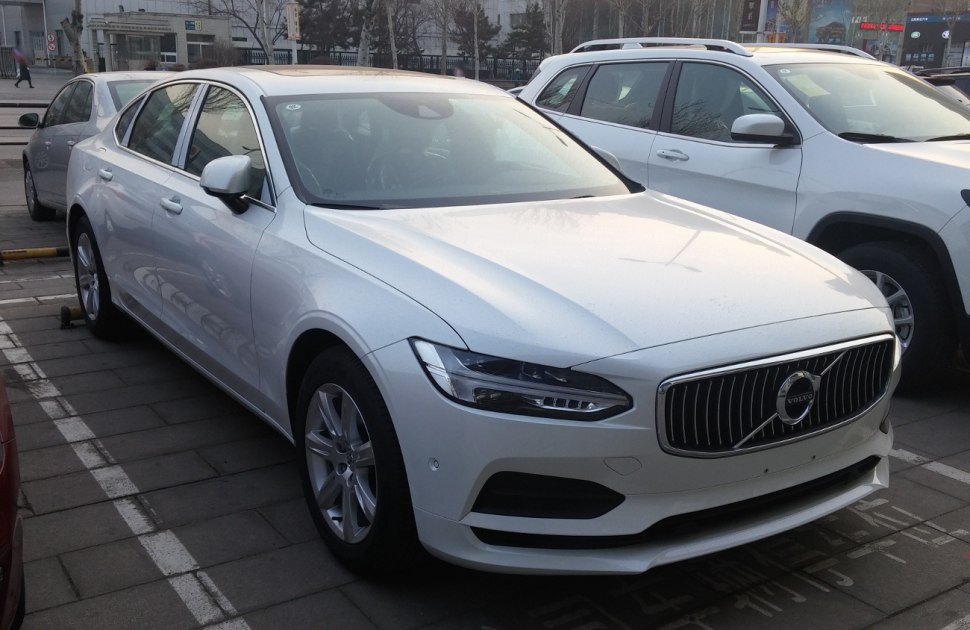 White luxury sedan with sleek LED headlights and vertical slat grille