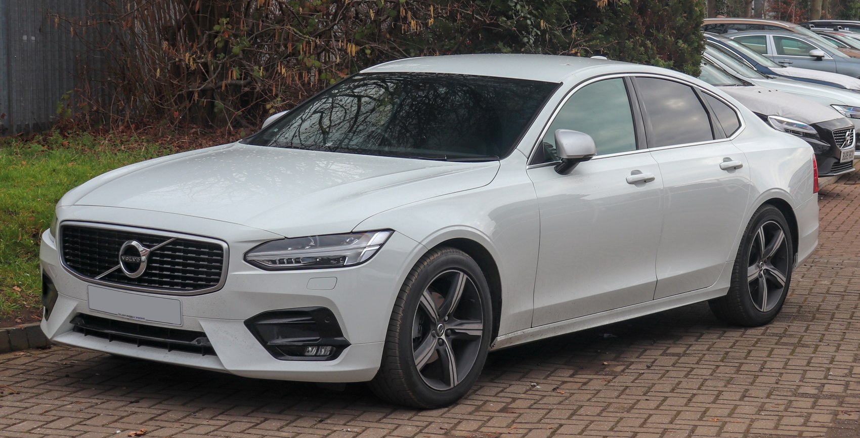 White luxury sedan with LED headlights and alloy wheels, front-side view