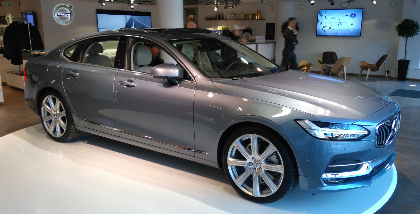 Luxury sedan with sleek headlights and alloy wheels in showroom