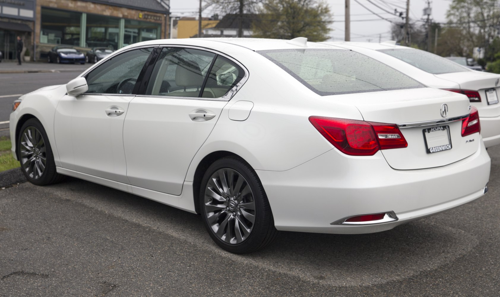 White luxury sedan rear 3-4 view with LED taillights and alloy wheels