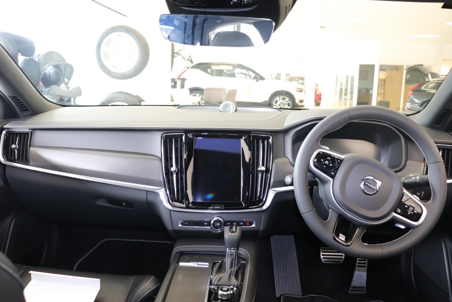 Dashboard with touchscreen, steering wheel, and carbon fiber trim