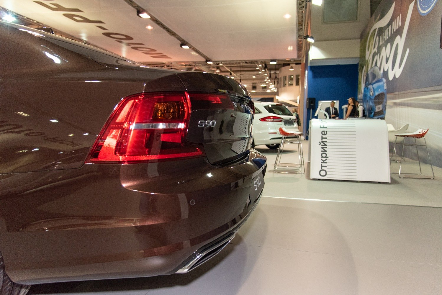 Rear tail light and bumper detail of a luxury sedan.