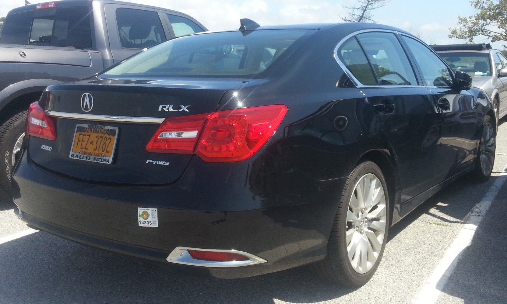 Rear view of black sedan with LED tail lights and alloy wheels