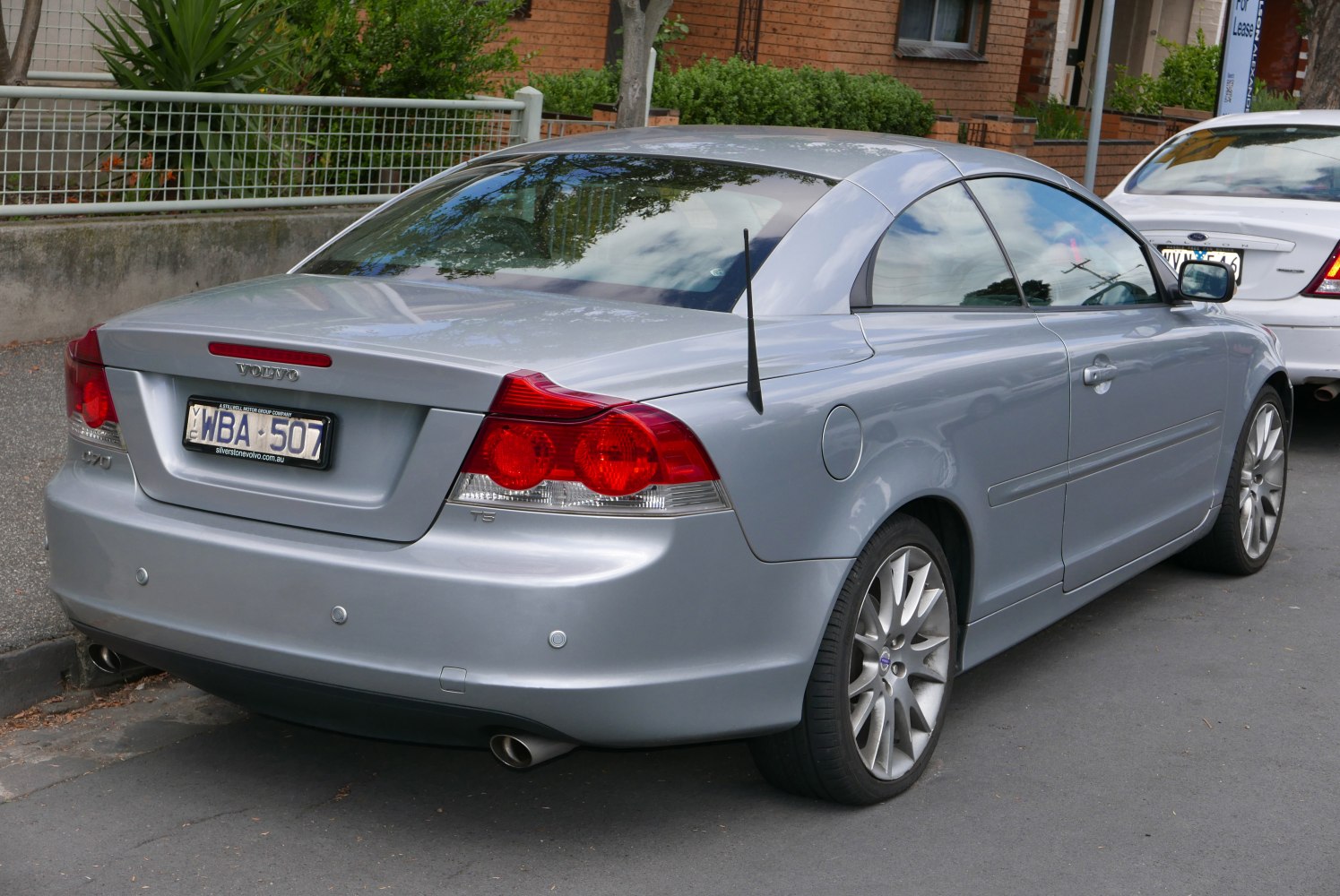 Silver coupe-cabriolet rear with dual exhaust and antenna