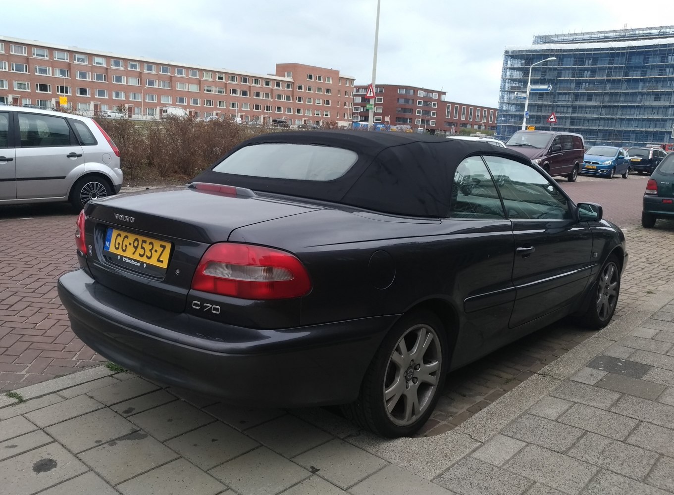Rear view of a convertible with black soft top roof and distinct tail lights
