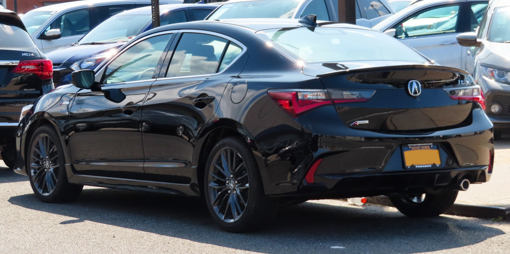 Rear and side view of a sleek black sedan with alloy wheels