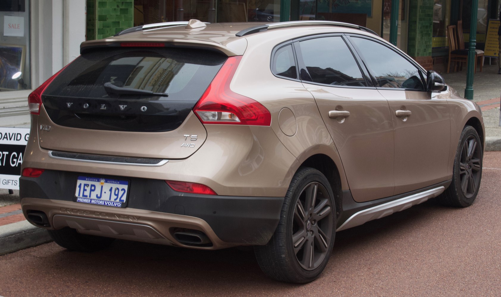 Sporty rear view with taillights, dual exhausts, and roof rails.