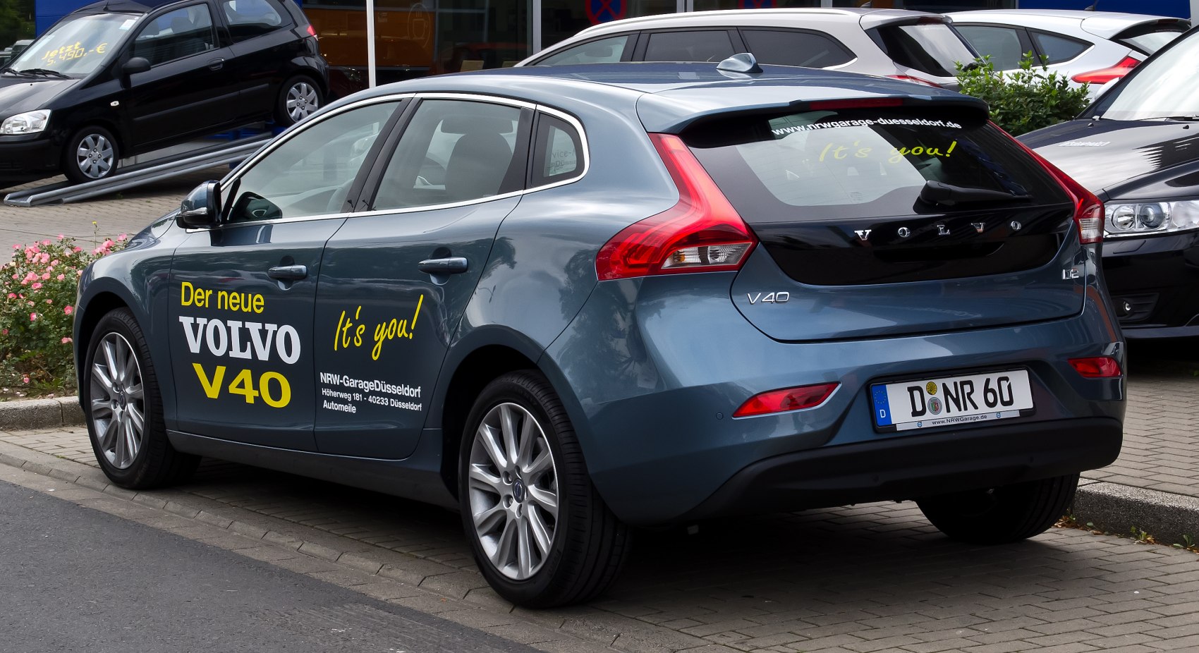 Rear side view of hatchback with distinctive taillights and advertising decals