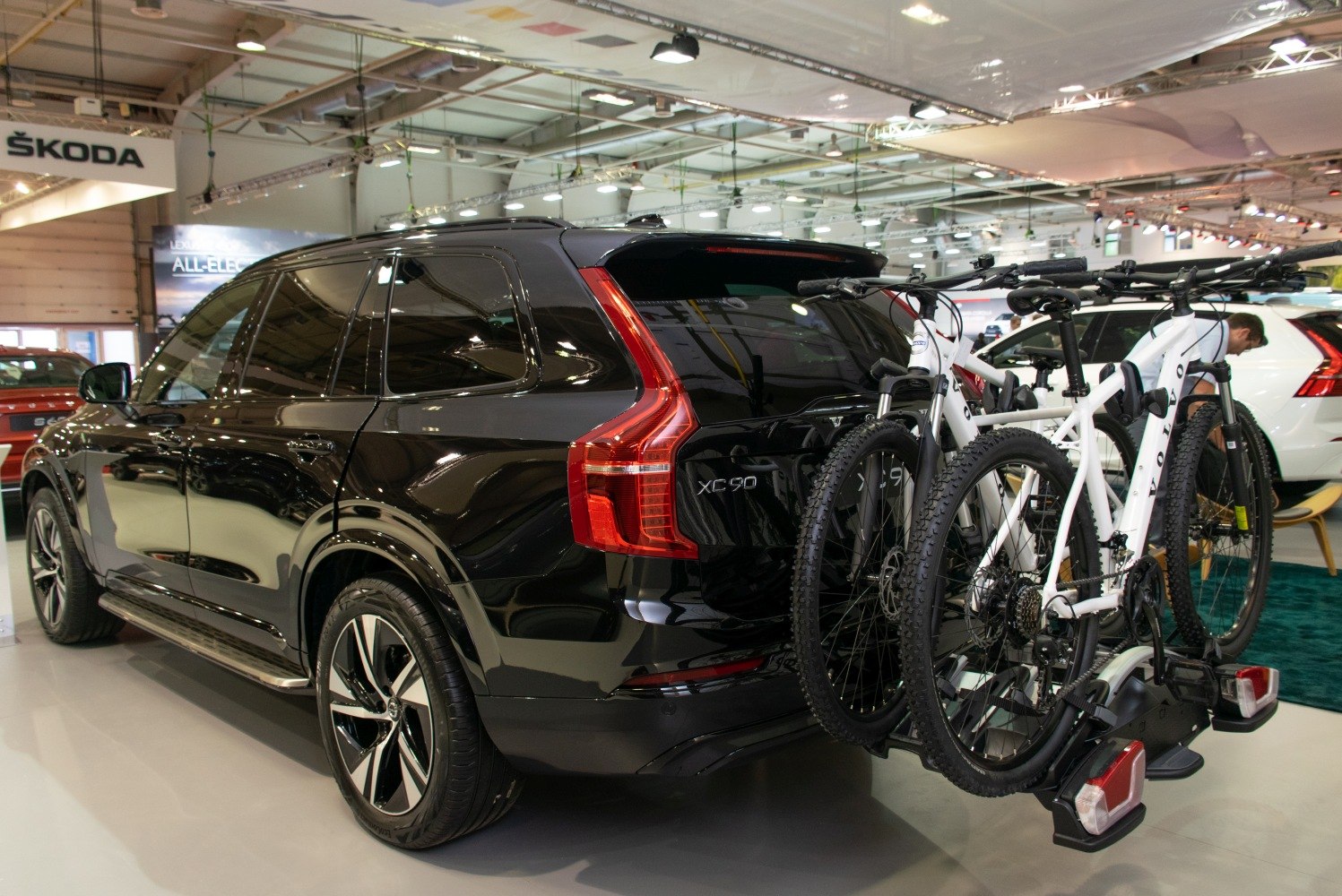 Black SUV with rear bike rack carrying two white bicycles