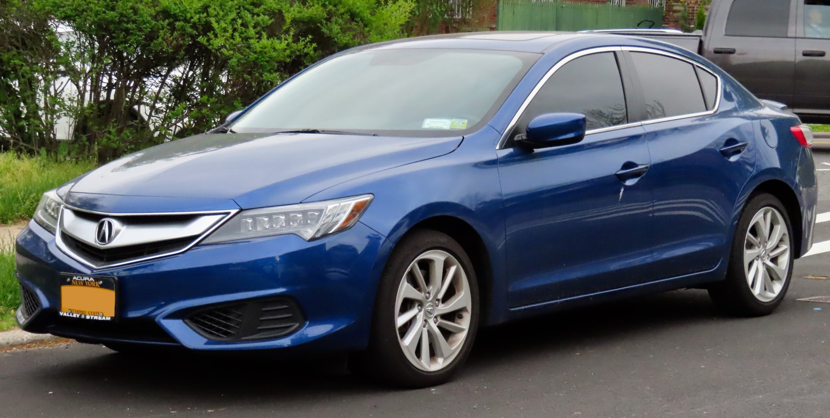 Front and side view of blue sedan with LED headlights and alloy wheels