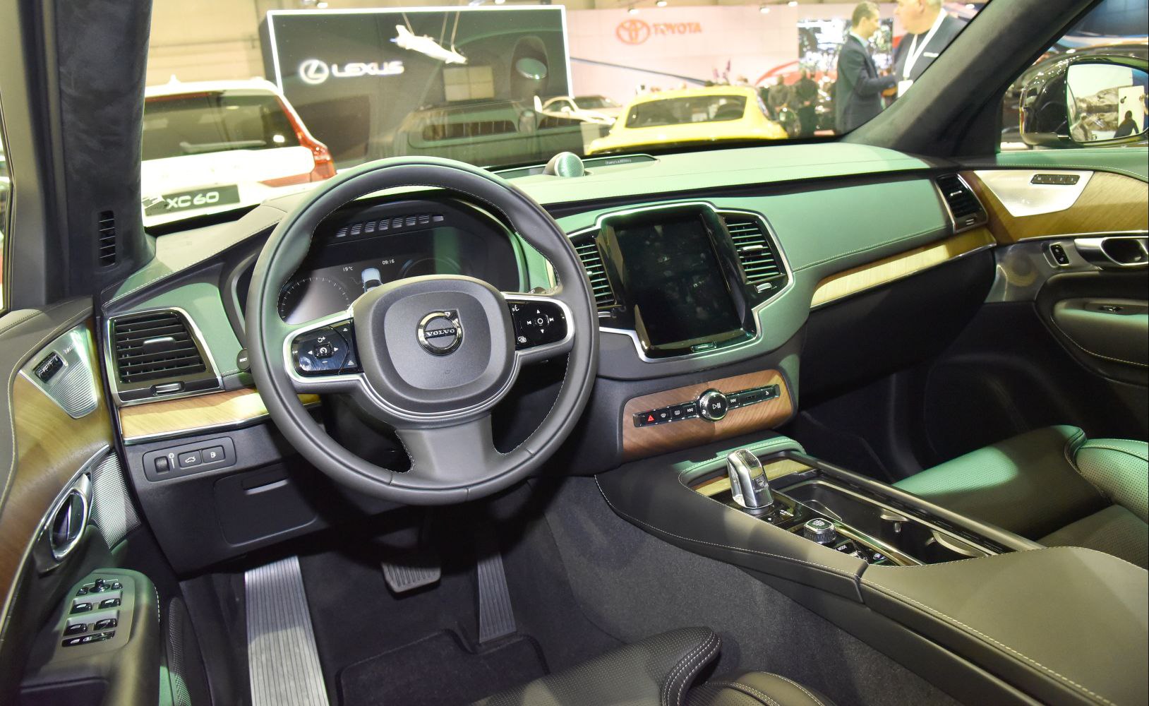 Luxury SUV interior with wood trim, large touchscreen, and multifunction steering wheel